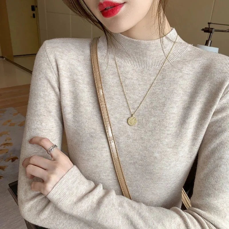 Women's slim fit long sleeve viscose pullover top in apricot colour on a hanger.