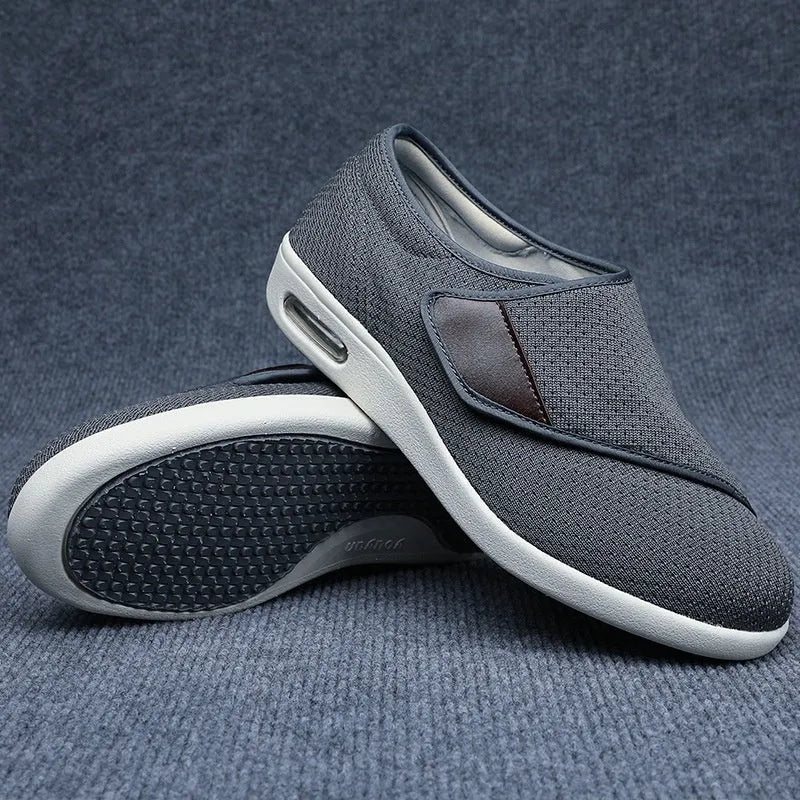Beige and grey leisure shoes with a wide fit and a black velcro strap closure.