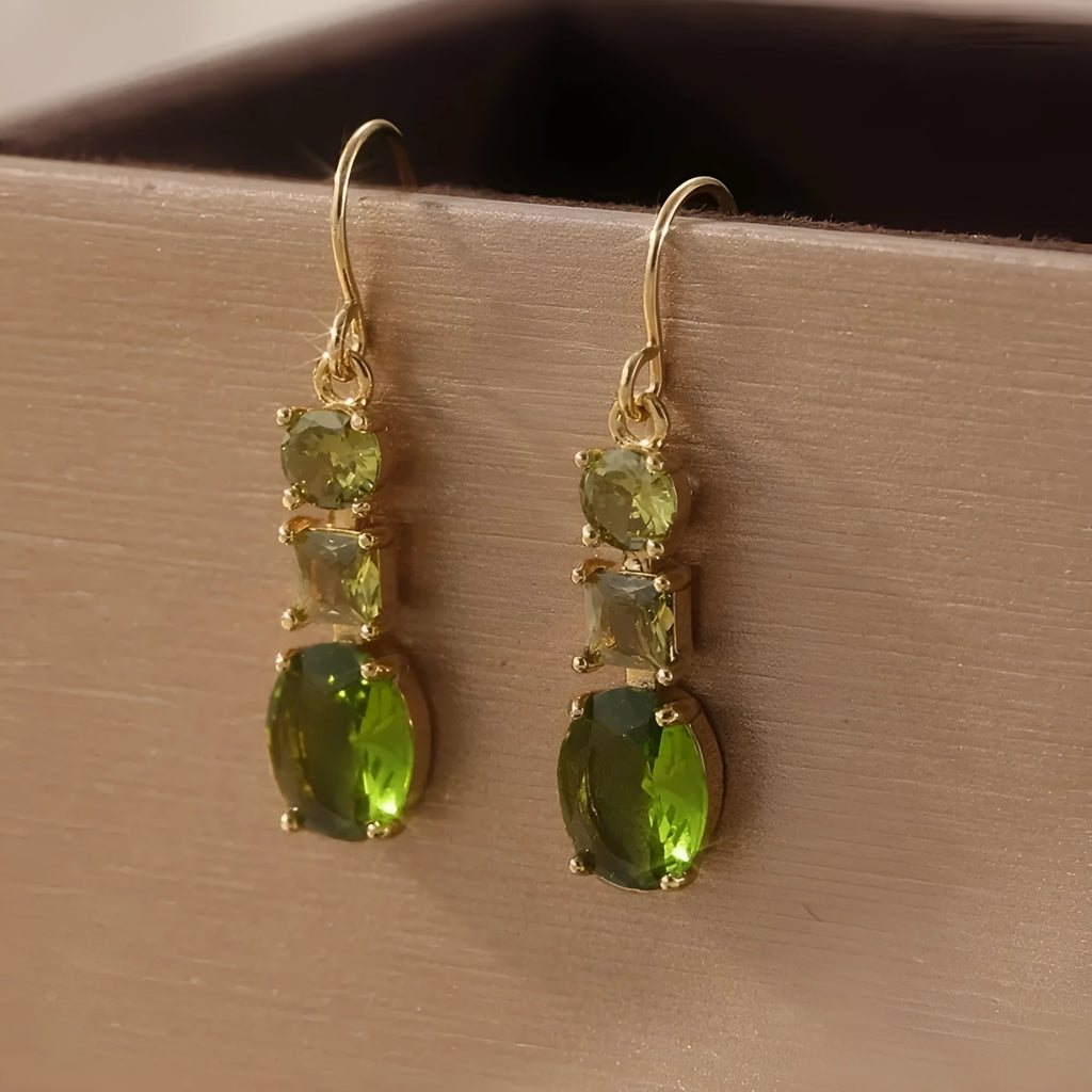 A pair of green square-shaped geometric copper drop earrings on a plain background.