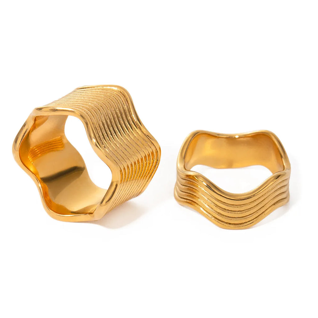 Stainless steel wide band ring with a geometric wave pattern, shown in silver and gold electroplated finishes.
