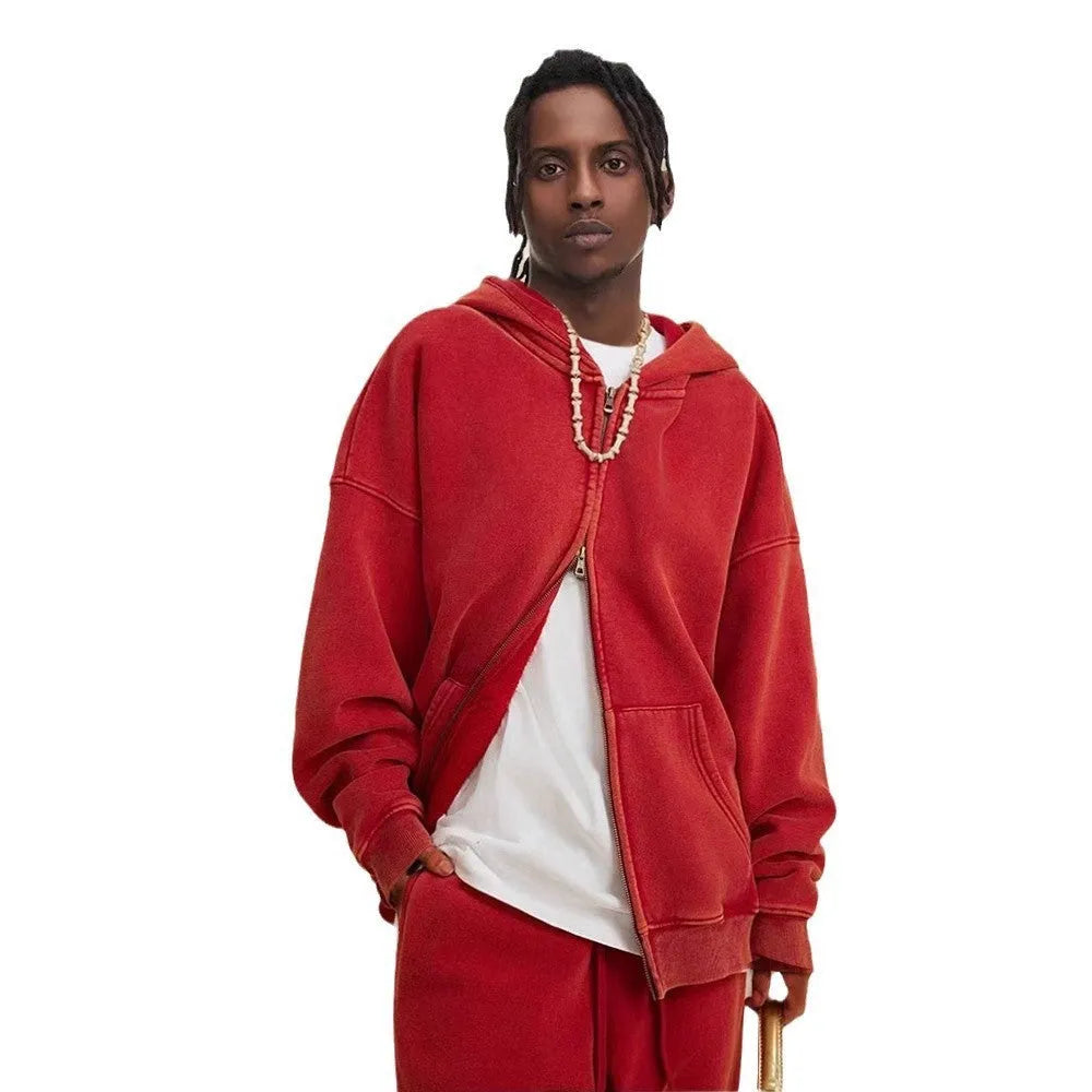 Man wearing a dark green fleece-lined hooded cardigan sweater with a double zipper.