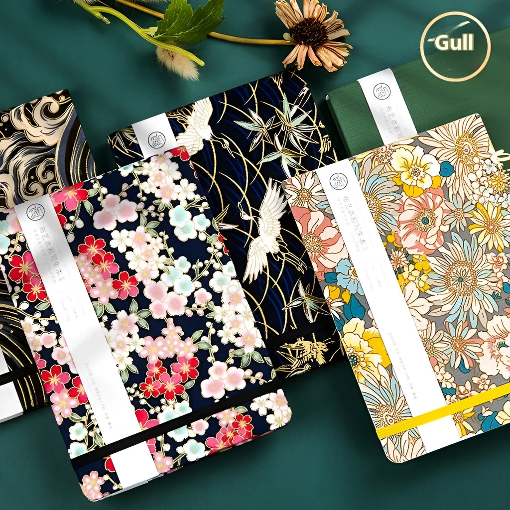Feiluniao fabric cover watercolour notebook open on a table with brushes, 185mm length