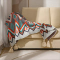 Acrylic sofa blanket with tassel fringe in neutral beige tone on grey sofa