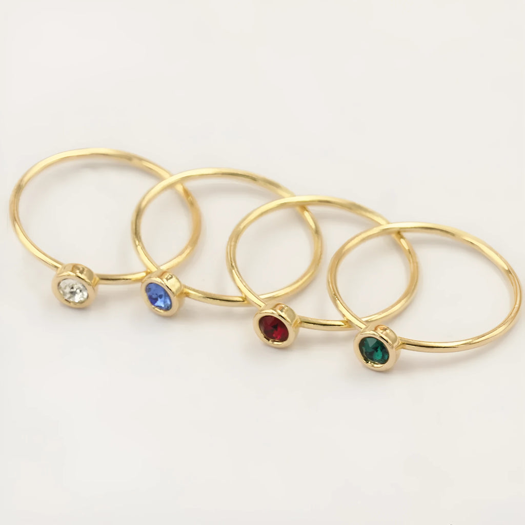 Women's copper knuckle ring with gilded finish and zircon stones in green, blue, red, and white.
