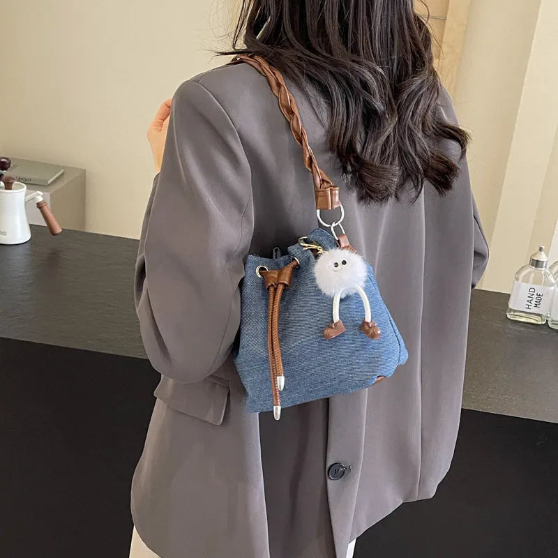 Blue synthetic leather cross-body bucket bag with sandwich pocket design