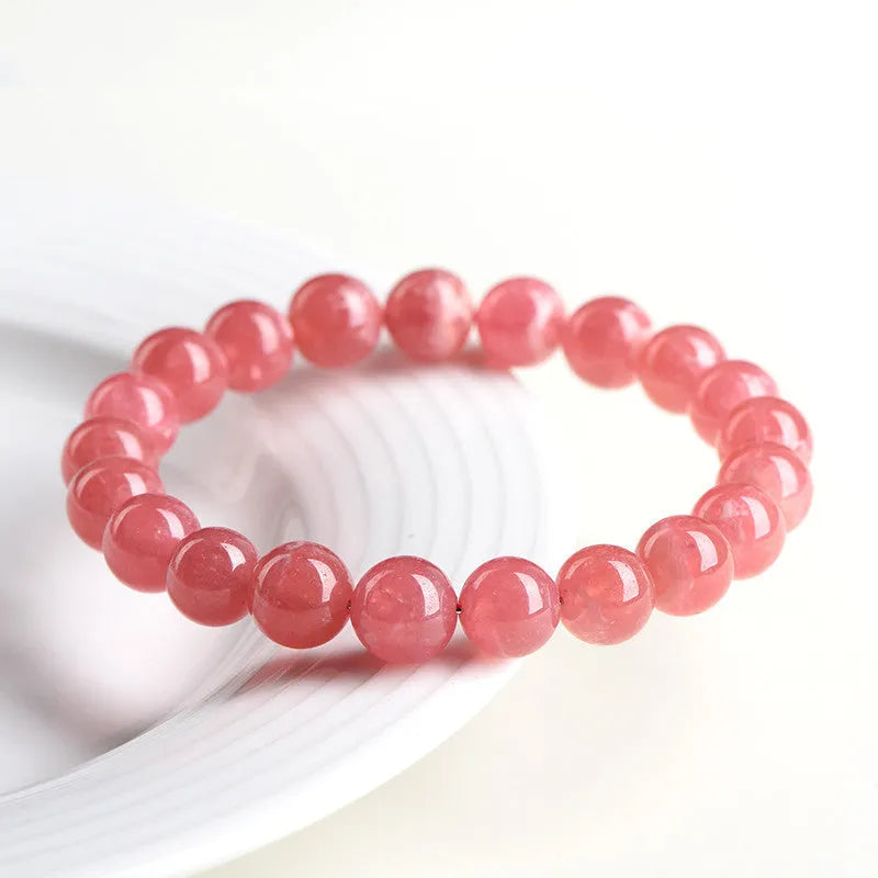 Women's geometric crystal bracelet with rhodochrosite pattern and a longevity lock charm.