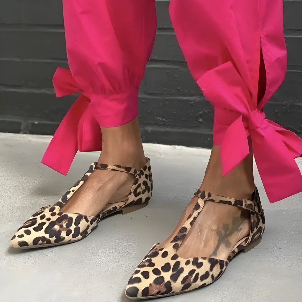 Women's leopard print pumps with a pointed toe, low chunky heel, and a cross shoulder strap.