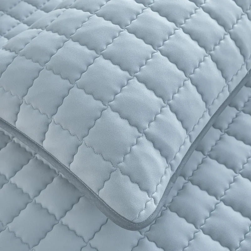 Blue washed cotton waterproof fitted sheet with elasticated corners on a mattress.