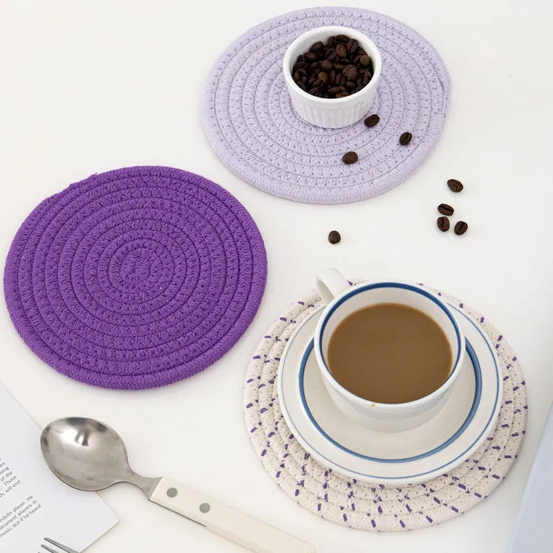 Three round cotton cord coasters in blue colour set on wooden table