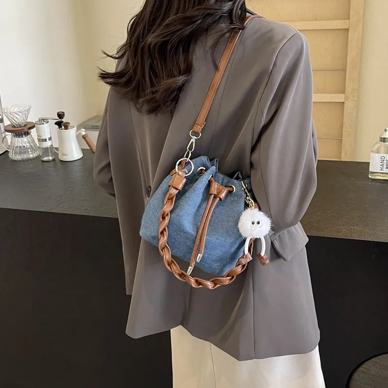 Blue synthetic leather cross-body bucket bag with sandwich pocket design