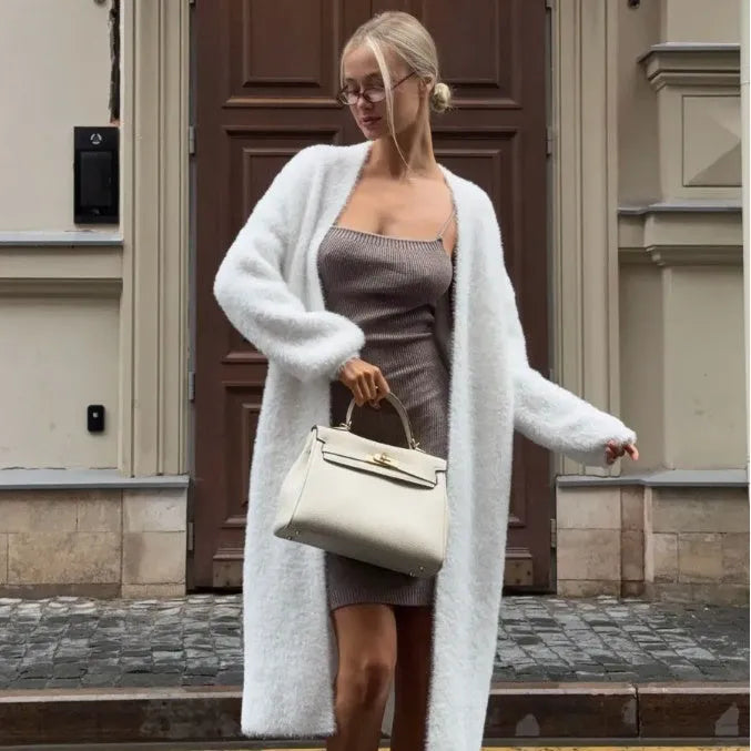 White longline knitted cardigan jacket with long sleeves on a hanger.