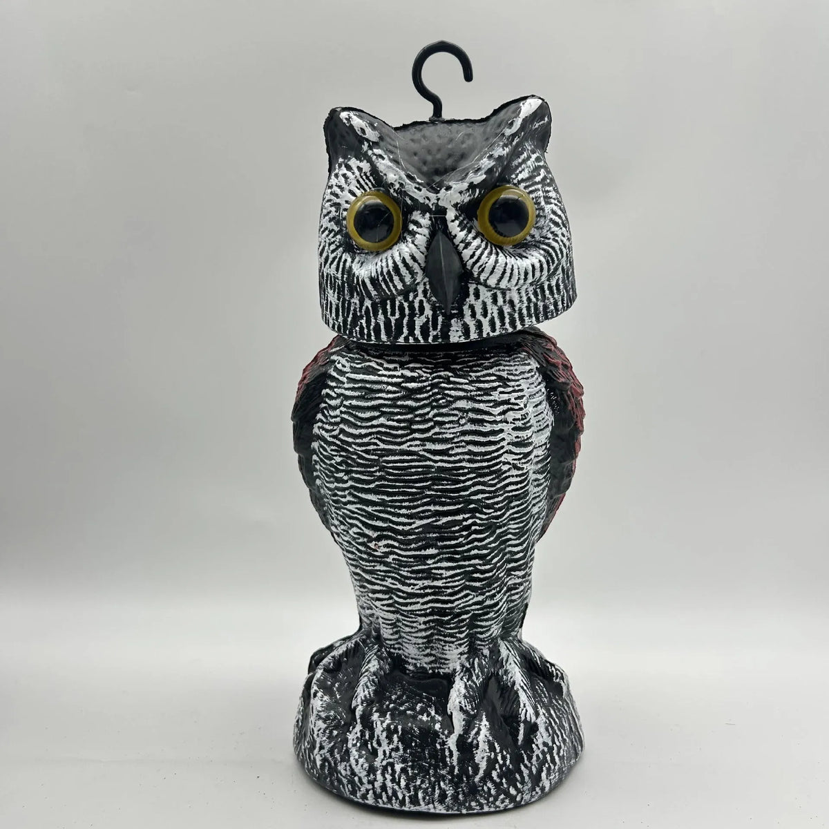 Polyethylene artificial owl bird scarer ornament with moving head, shown in a garden setting.
