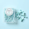Plastic push pins in macaron colours: cherry blossom pink, mint green and lavender, displayed in small boxes.