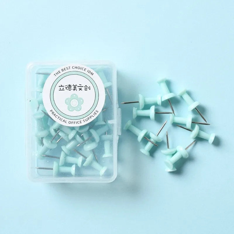 Plastic push pins in macaron colours: cherry blossom pink, mint green and lavender, displayed in small boxes.
