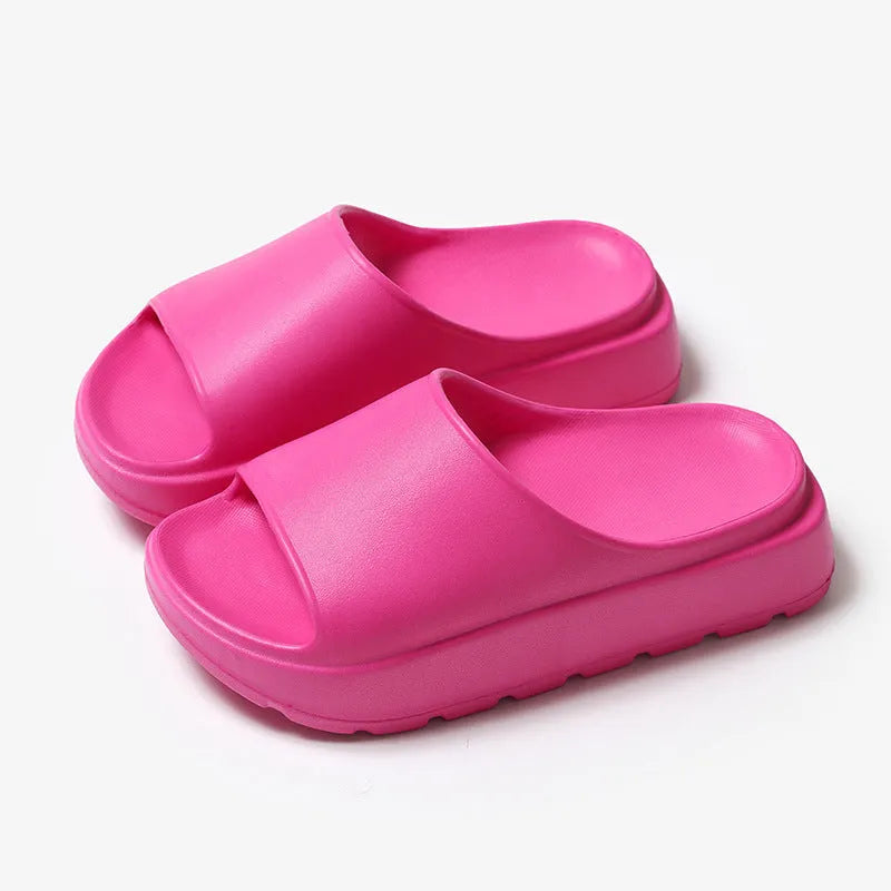 Women's thick-soled EVA beach slippers in beige, shown from the side on a sandy surface.