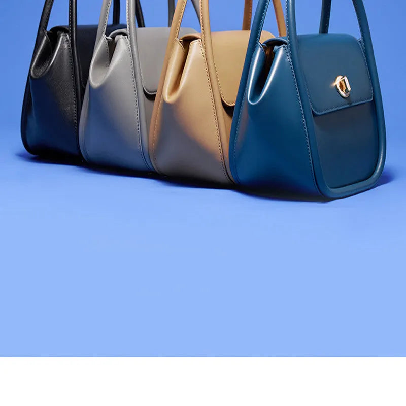 A wing-shaped women's leather tote bag with a buckle latch, shown in blue with a cross-body strap.