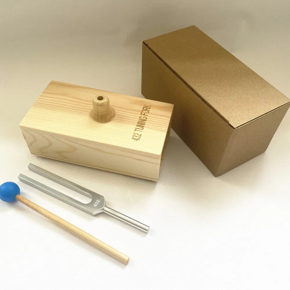 Aluminium alloy 432 Hz tuning fork with built-in speaker on kraft paper box.
