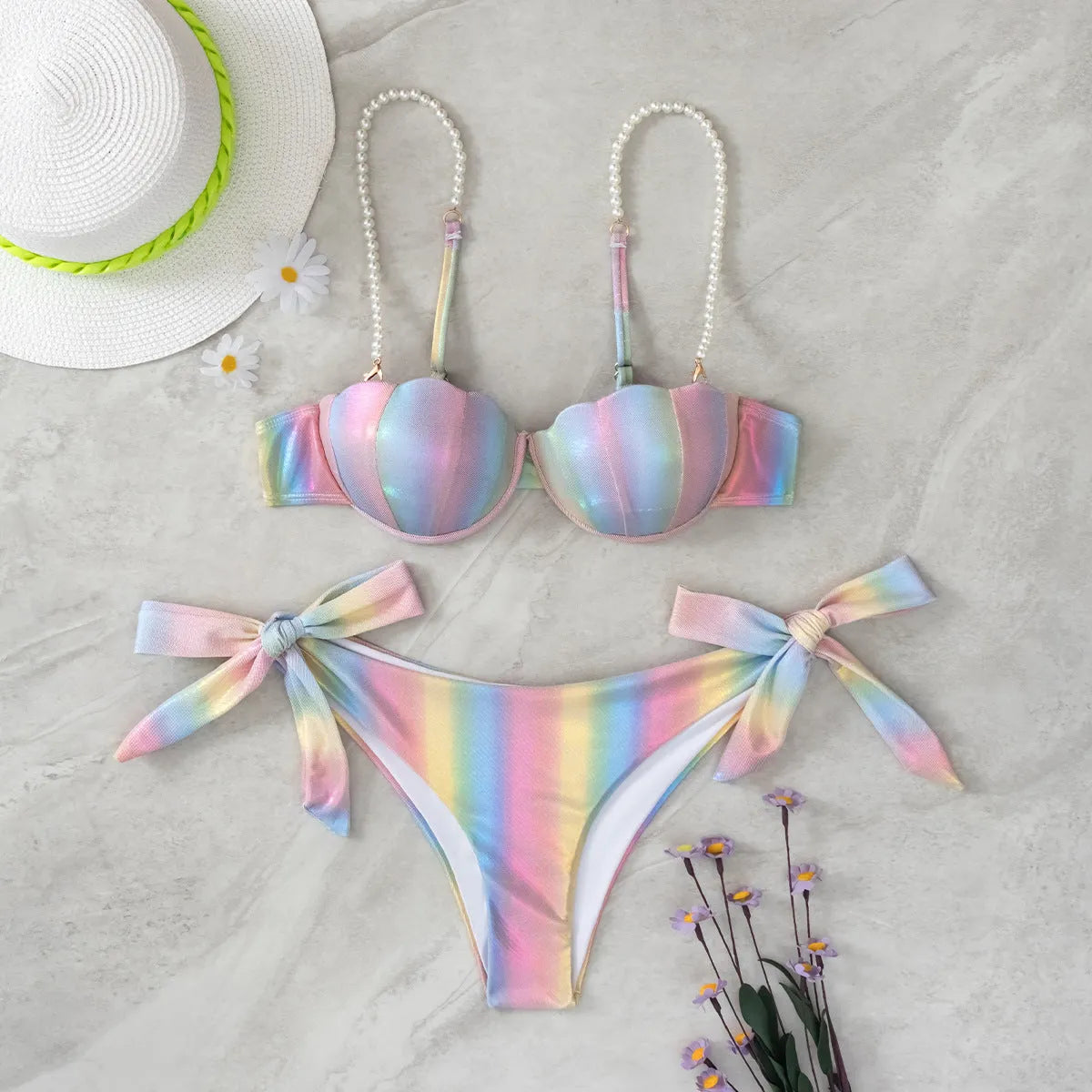 Rainbow coloured women's bikini swimsuit with split tied design on a mannequin