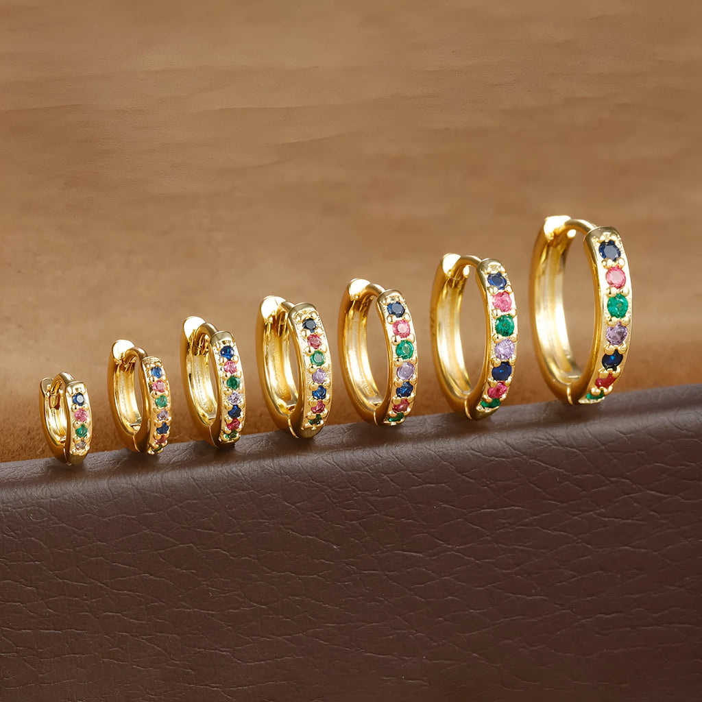 Gold, rose gold, and silver circle stud earrings with a perforated geometric design and zircon detail.