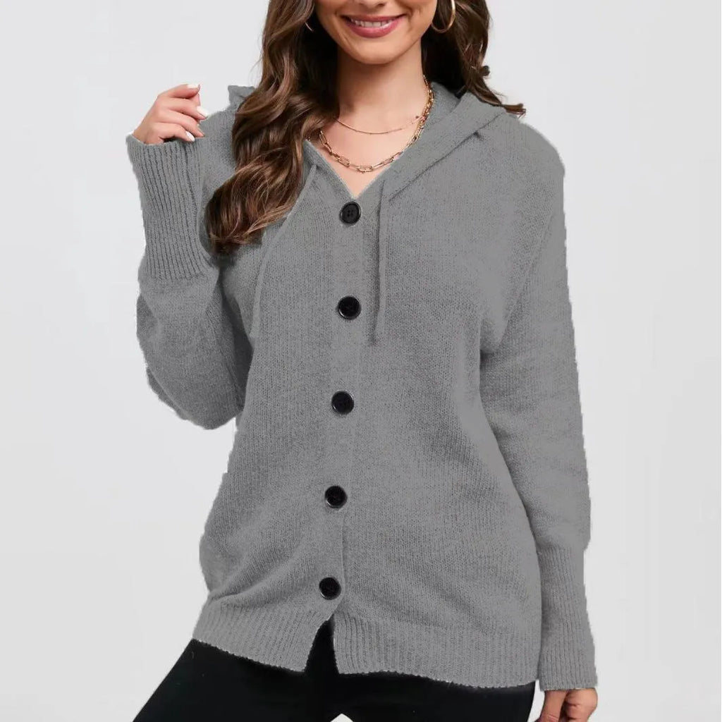 Woman wearing a thick, loose-fit hooded cardigan sweater in a solid colour with a 3D textured pattern.