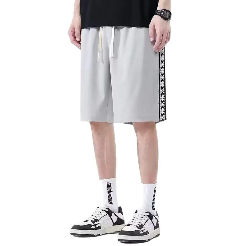 Men's loose-fit black track pants with an elasticated waist, shown on a hanger.