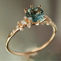 Gold coloured geometric ring with chamfered square pattern and claw-set zircon stones.