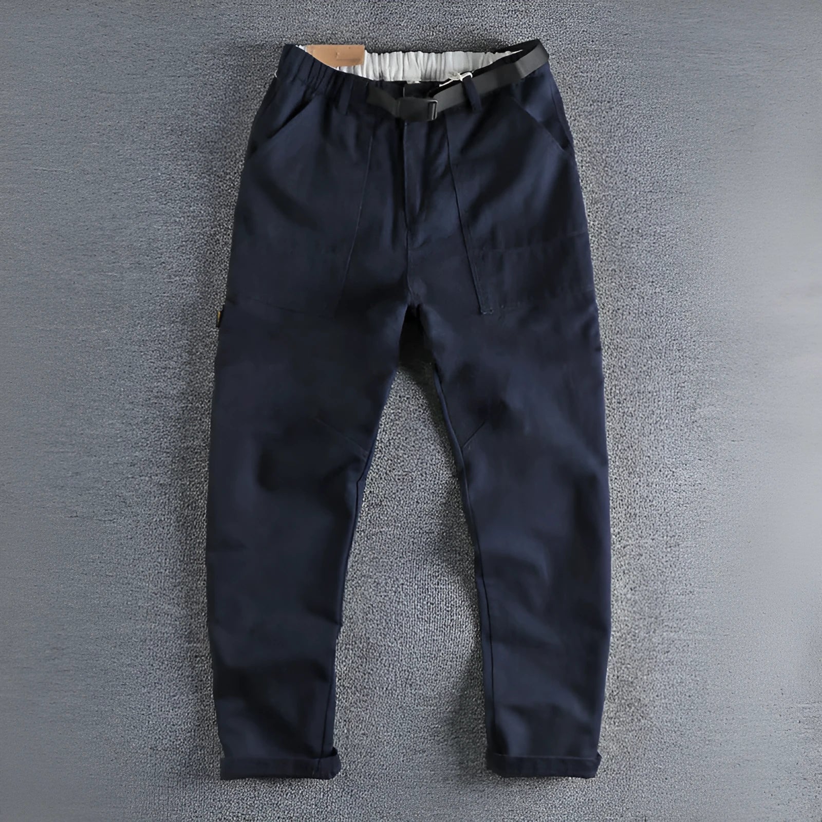 Men's khaki cotton work trousers with an N I buckle belt on a mid-rise waist.