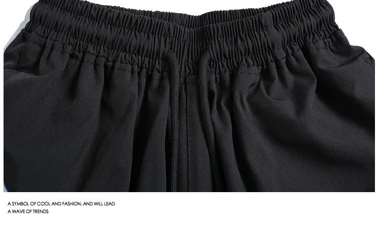 Black and grey loose fit sports shorts with elasticated waistband and tie closure