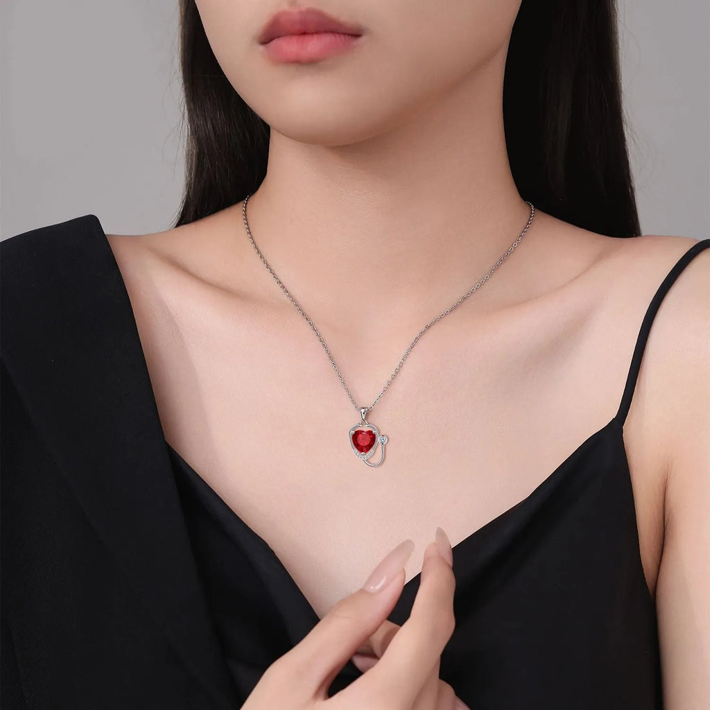 Red diamond coloured women's necklace with stethoscope, wings and cross pendant design