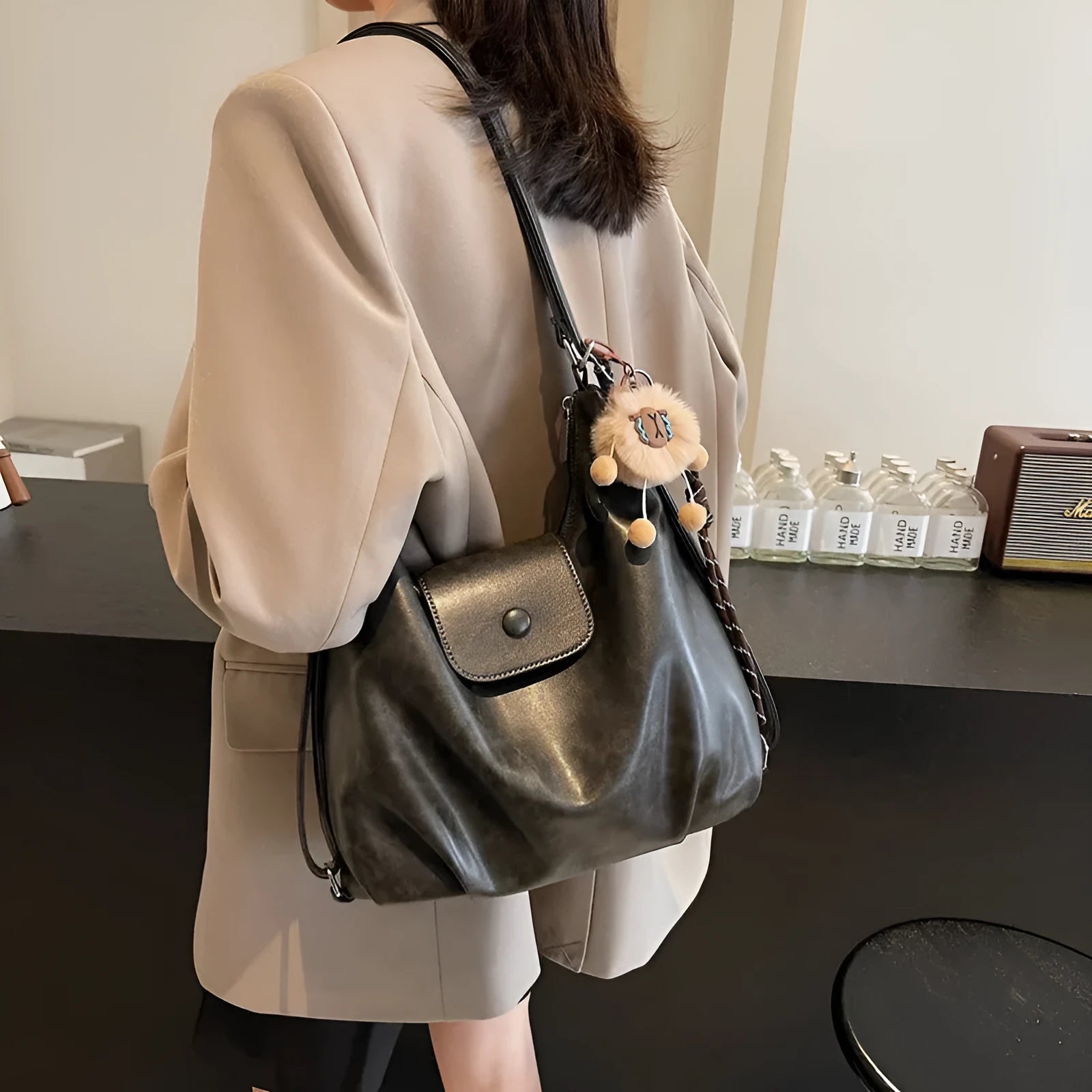 Black leather PU women's single-shoulder backpack with textured finish and horizontal square shape