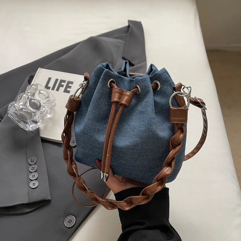 Blue synthetic leather cross-body bucket bag with sandwich pocket design