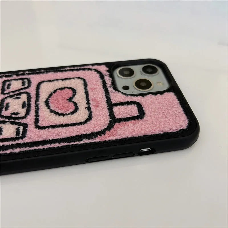 Pink iPhone case with a textured, towel-like embroidered design on the back.