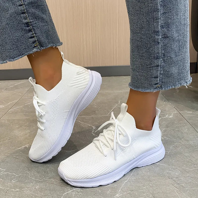 Women's low-top mesh running shoe in creamy white with a round toe and flat rubber sole.