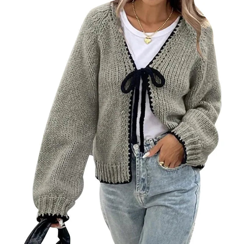Gray lace-up front cardigan with crocheted flower detail on a model, showing loose long sleeves.