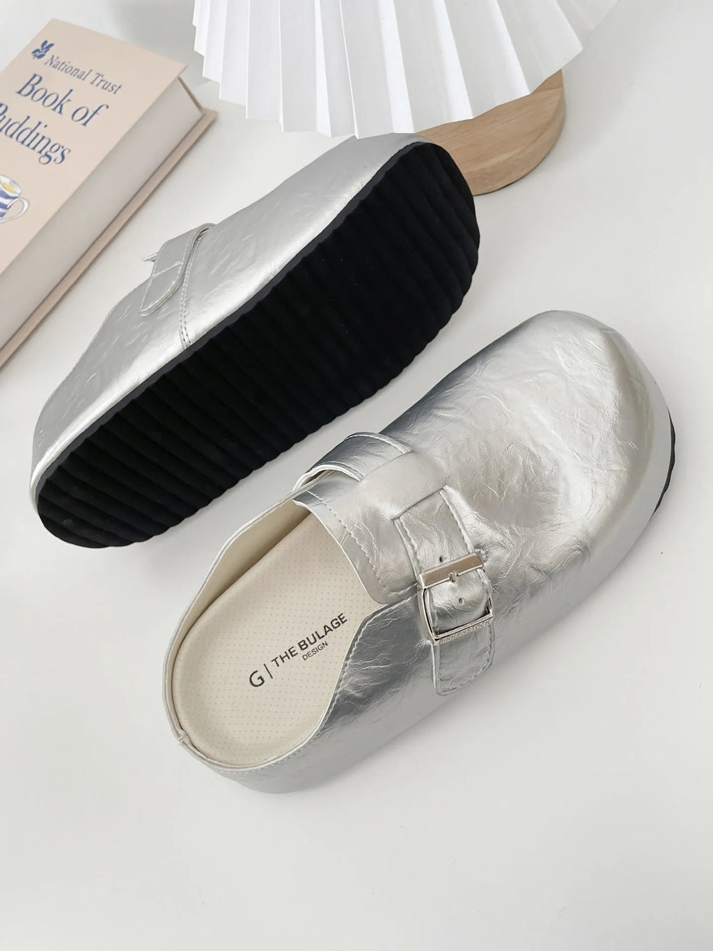 Flat buckle casual sneakers in yellow, creamy-white, silver, and black colours on a white background.