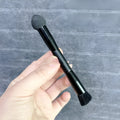 Black sponge stick concealer brush with wooden handle for under-eye makeup application
