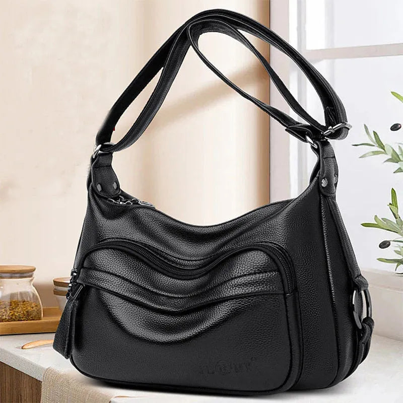 Large black or blue PU crossbody bag with organised internal compartments and soft handle