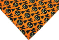 Halloween dog bandana with pumpkin and spider web patterns on reversible black and orange triangle bib