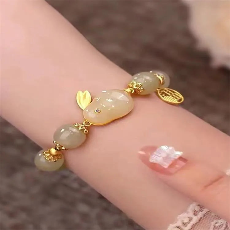 Women's green jade bracelet with black hand charm and hare pendant featuring fu character and lily motifs