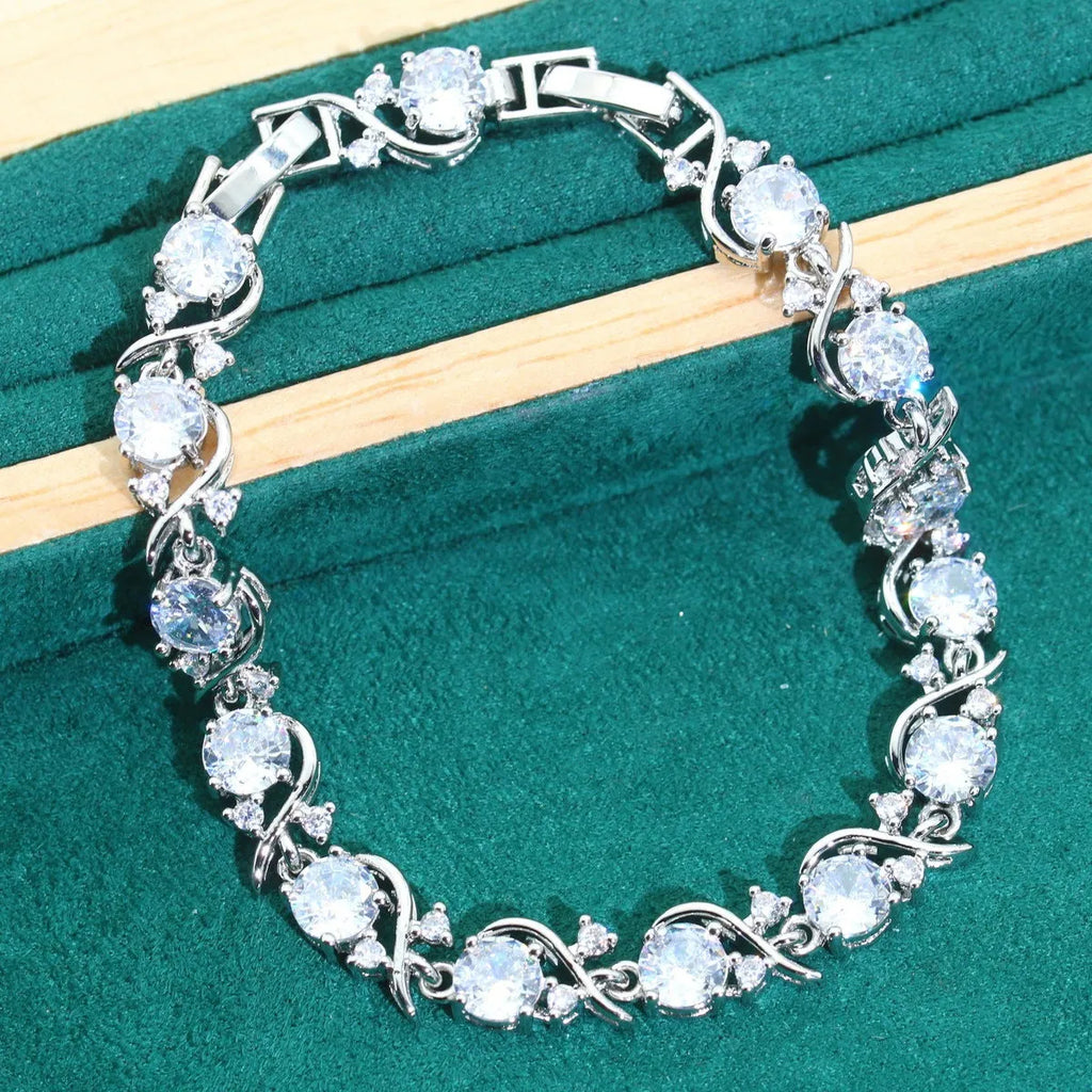 Four-piece bridal jewellery set showing alloy pendant necklace, bracelet, earrings, and ring on a white background.
