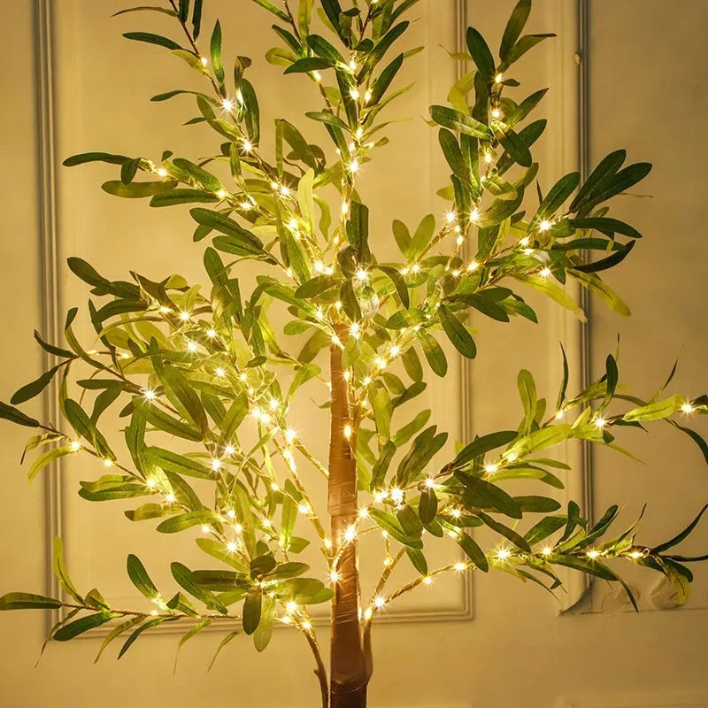 Tall 1.8m artificial olive tree lamp with warm white LEDs illuminating simulation leaves in a courtyard setting.