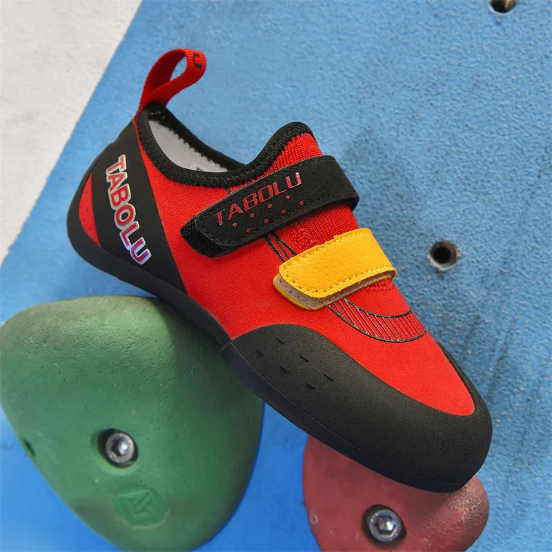 Beginner rock climbing shoes in black and red with Velcro strap and rubber sole.