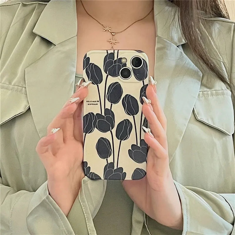 Black silicone iPhone case featuring a printed tulip flower design on the back.
