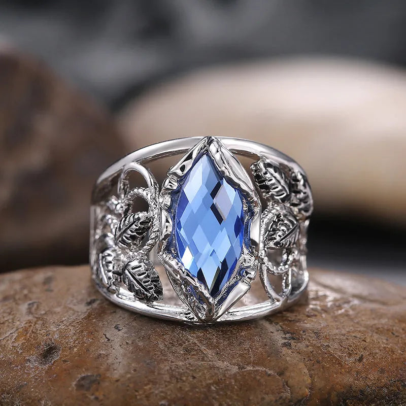 Blue horse eye-shaped crystal ring for women on a hand, showing geometric alloy design.