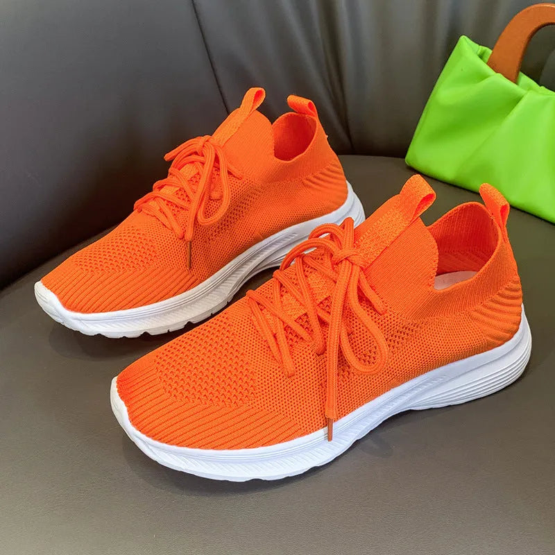 Women's low-top mesh running shoe in creamy white with a round toe and flat rubber sole.