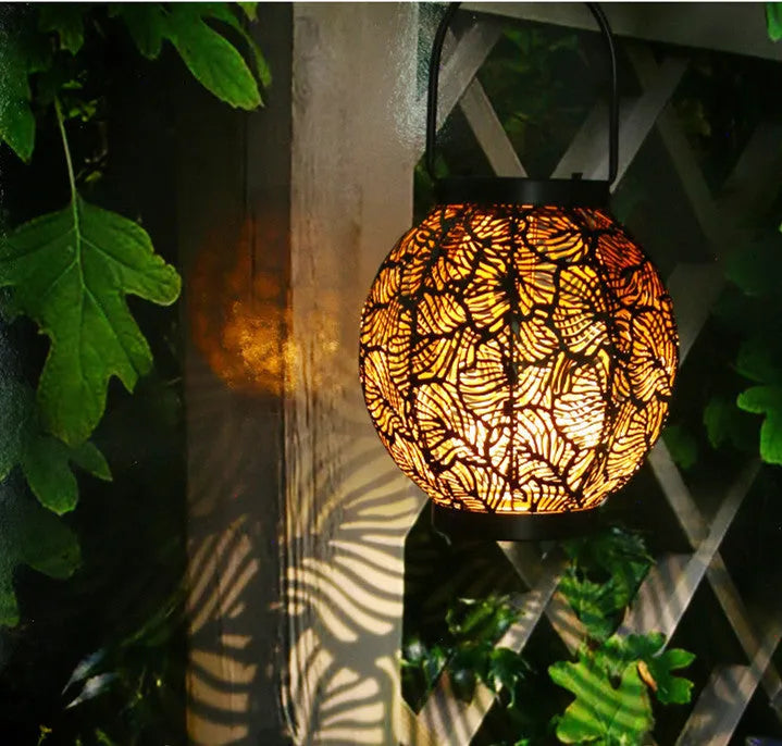 Solar-powered courtyard lamp with hollow iron decorative design showing warm white LED illumination