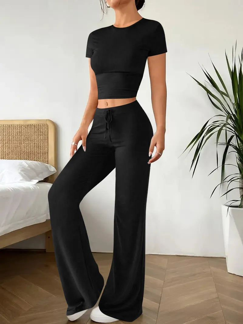 Black women's high waist trousers and short sleeve top coordinated suit set on a hanger.