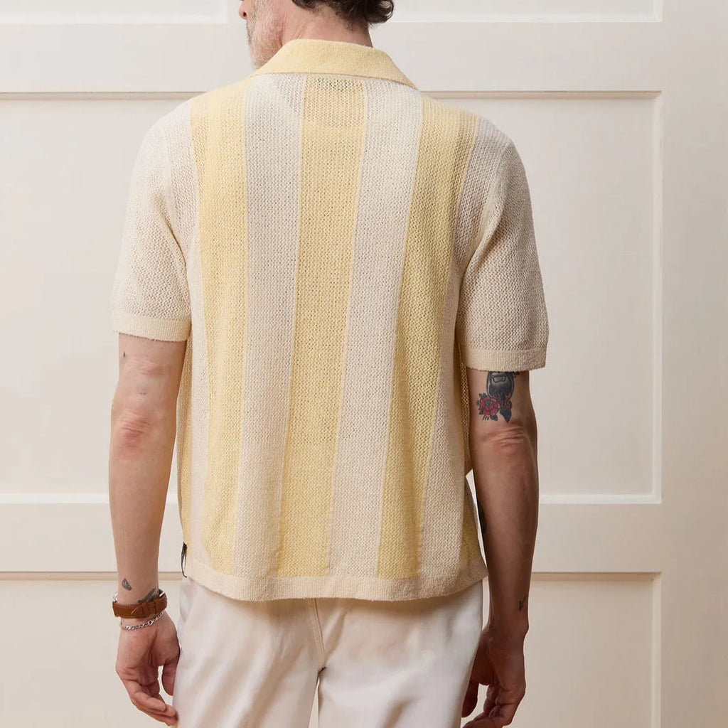 Yellow asymmetric hollow-out short-sleeved polo shirt on a hanger