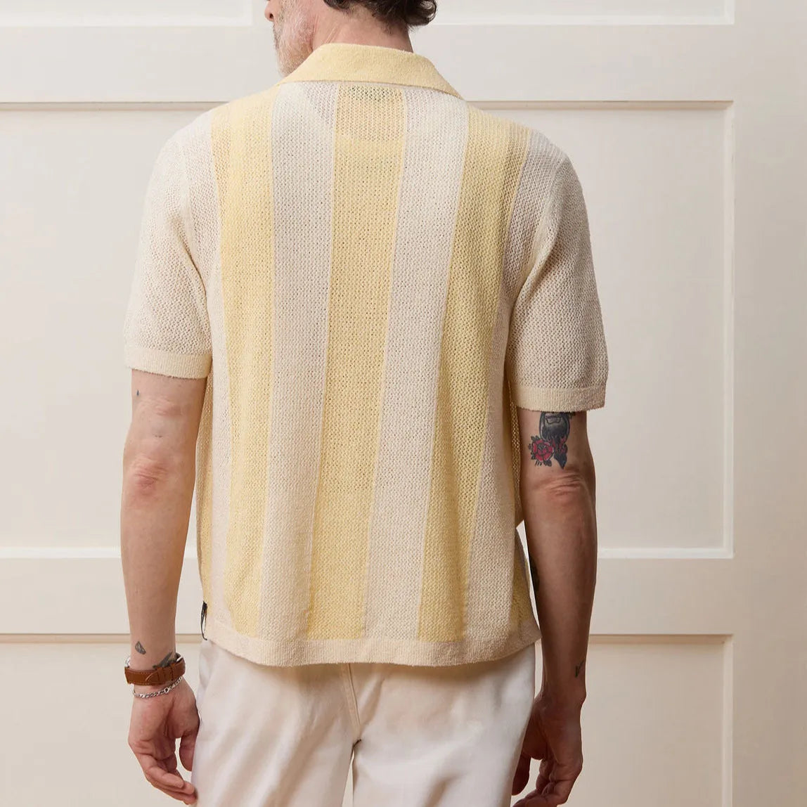 Yellow asymmetric hollow-out short-sleeved polo shirt on a hanger
