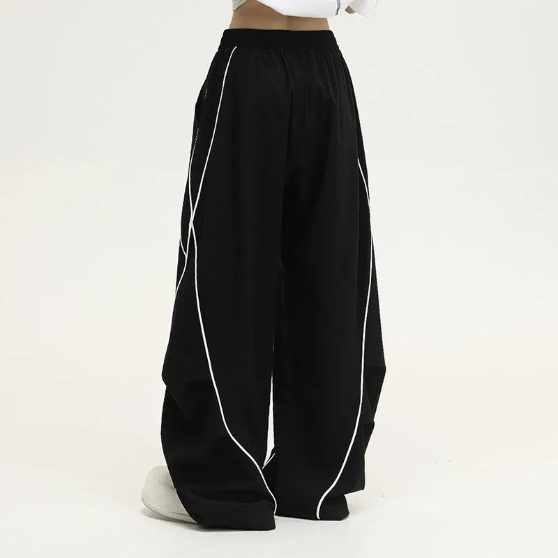 Black and white striped wide-leg hip hop trousers with front pleats on a mid-waist.